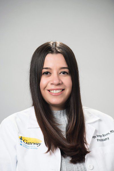 Woman smiling in a white lab coat.